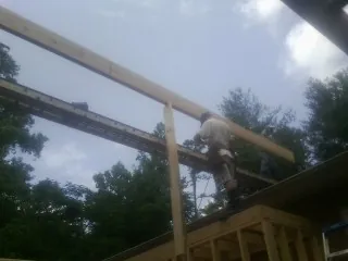 Carpenter setting a ridge beam over a new addition frame — Ice Dam Removal by Roofing Brothers in Mequon